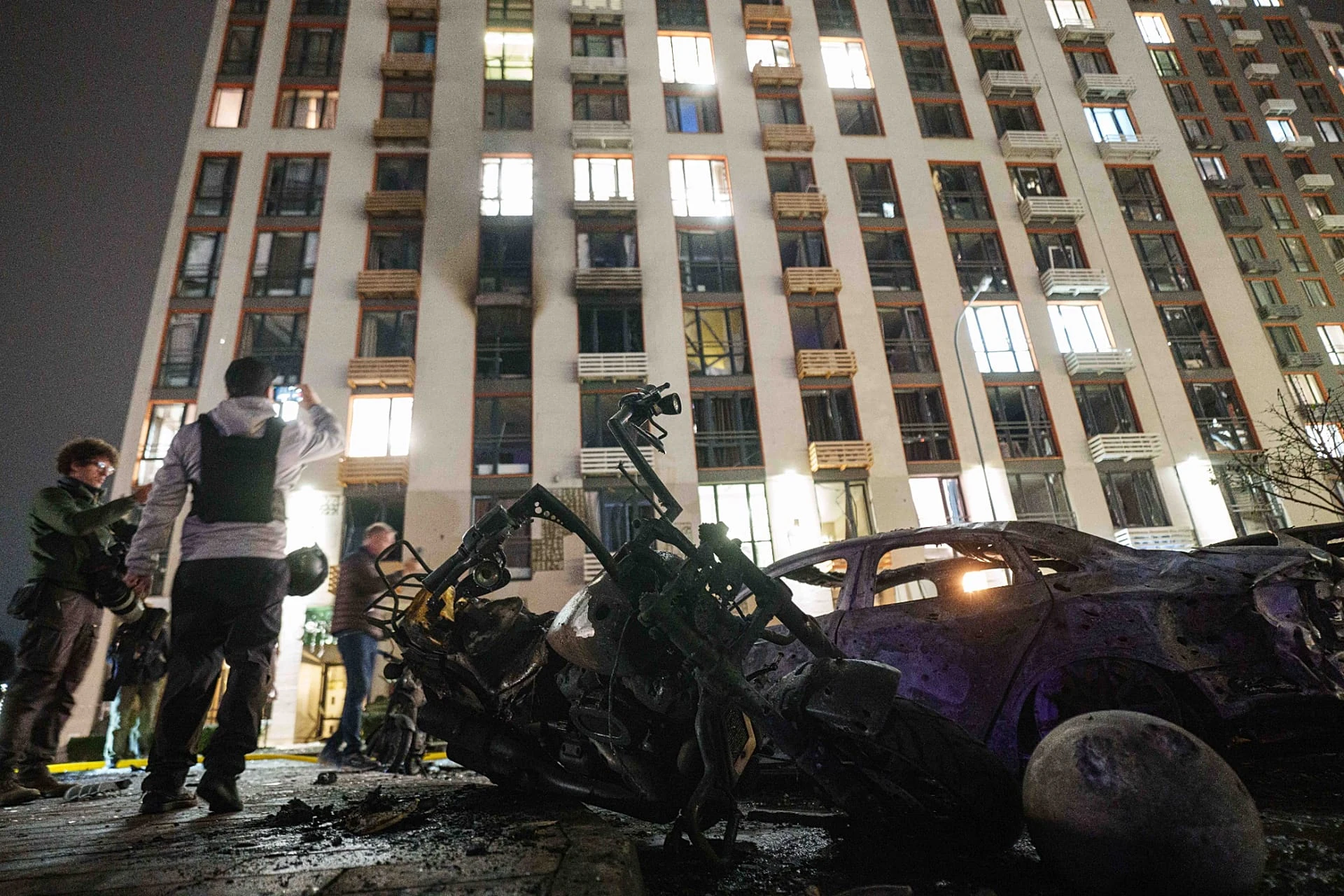 Police officers search for fragments of a Shahed drone in front of a residential building in Kyiv, 12 October, 2026